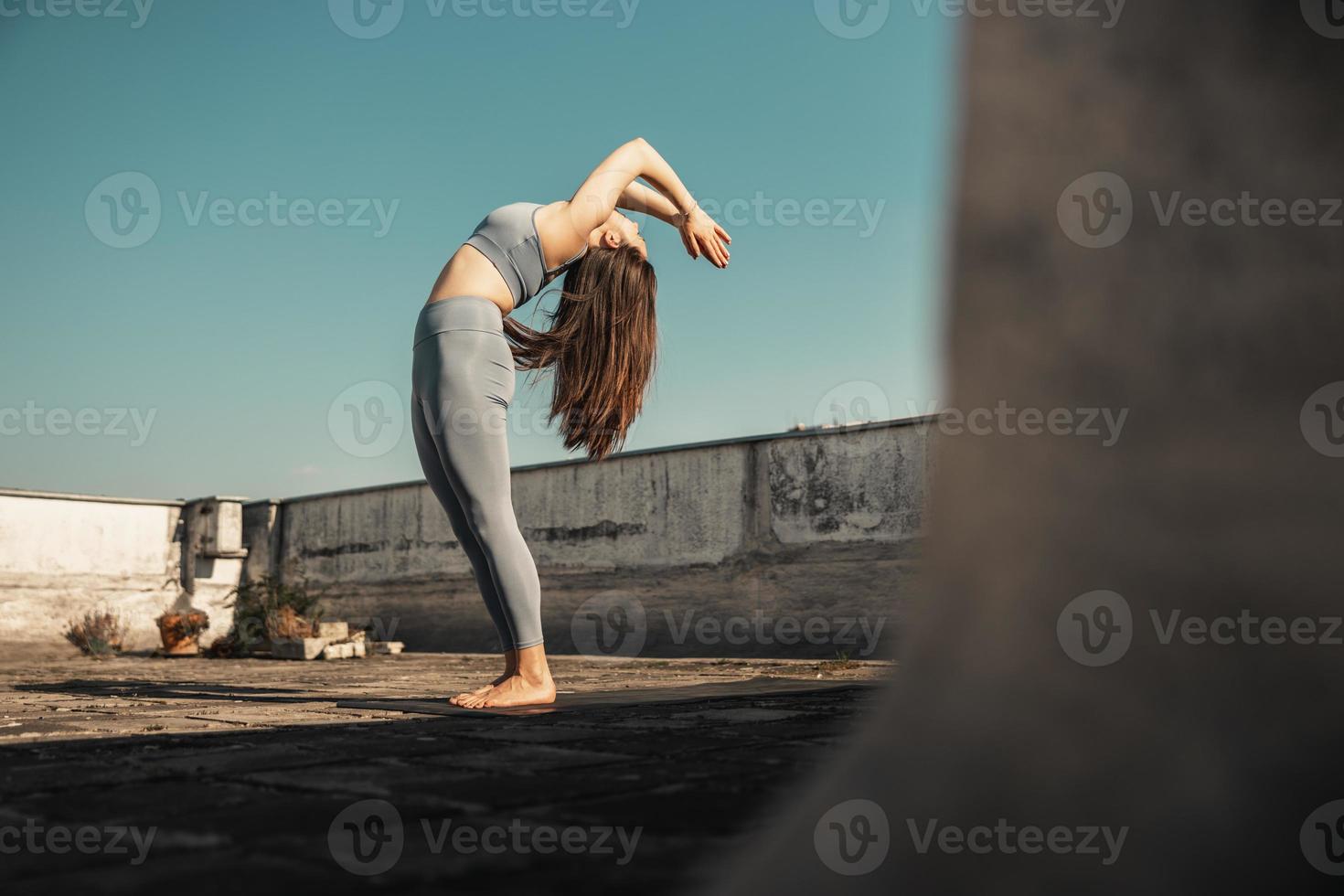 Woman Doing Yoga Outdoors On A Rooftop Terrace photo