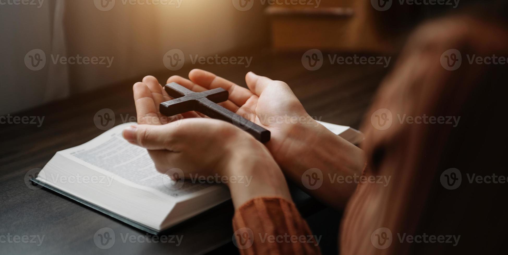 Woman sitting and studying the scriptures.The  wooden cross in the hands. Christian education concepts The Holy Scriptures open photo