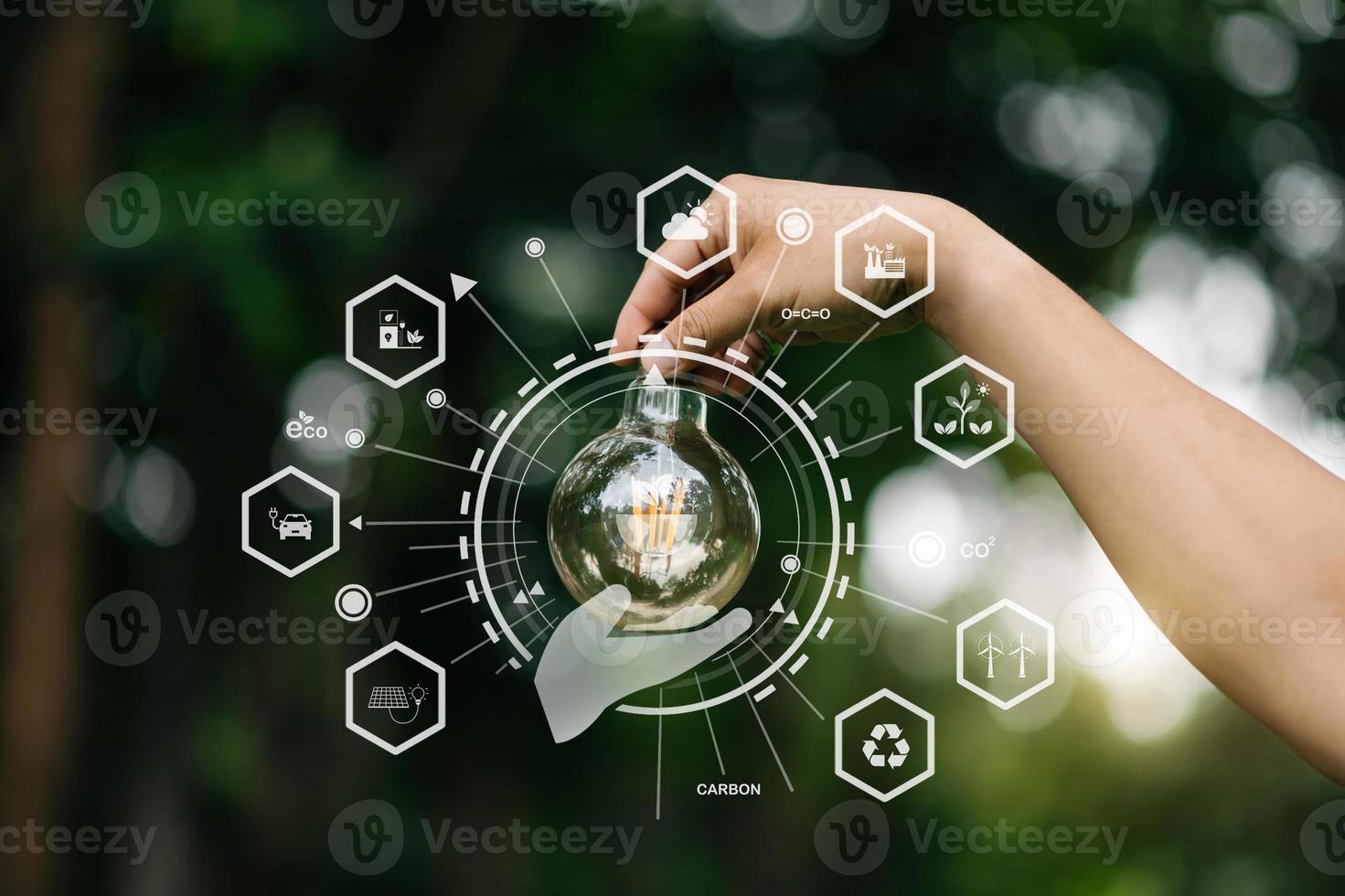 Hand holding anti nature light bulb on green leaf with renewable and sustainable development energy source icon. for renewable, love the world concept photo