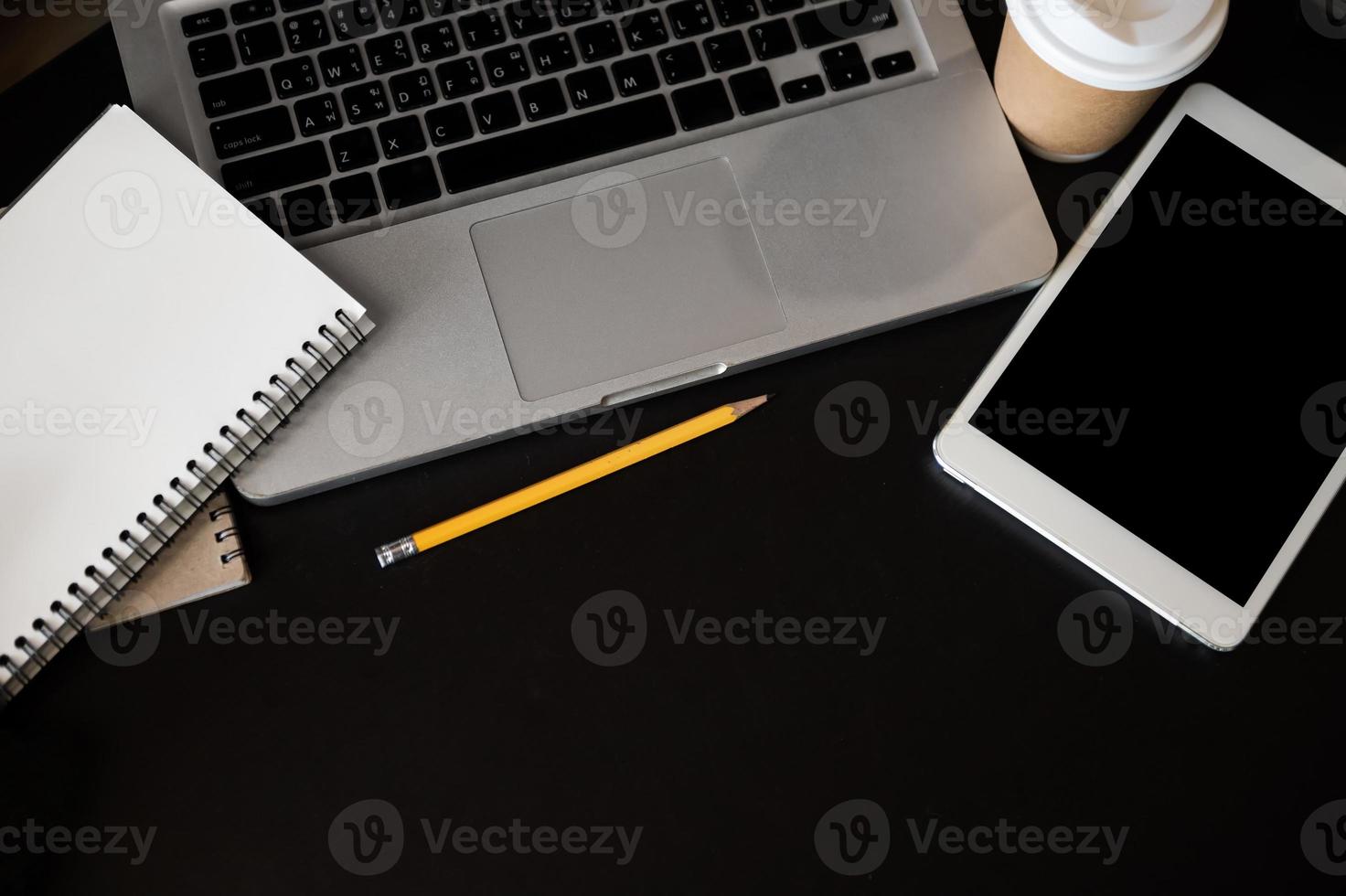 office desk table with a lot of things tablet, laptop ,smartphone ,notepad and coffee cup notepad . Top view with copy space photo