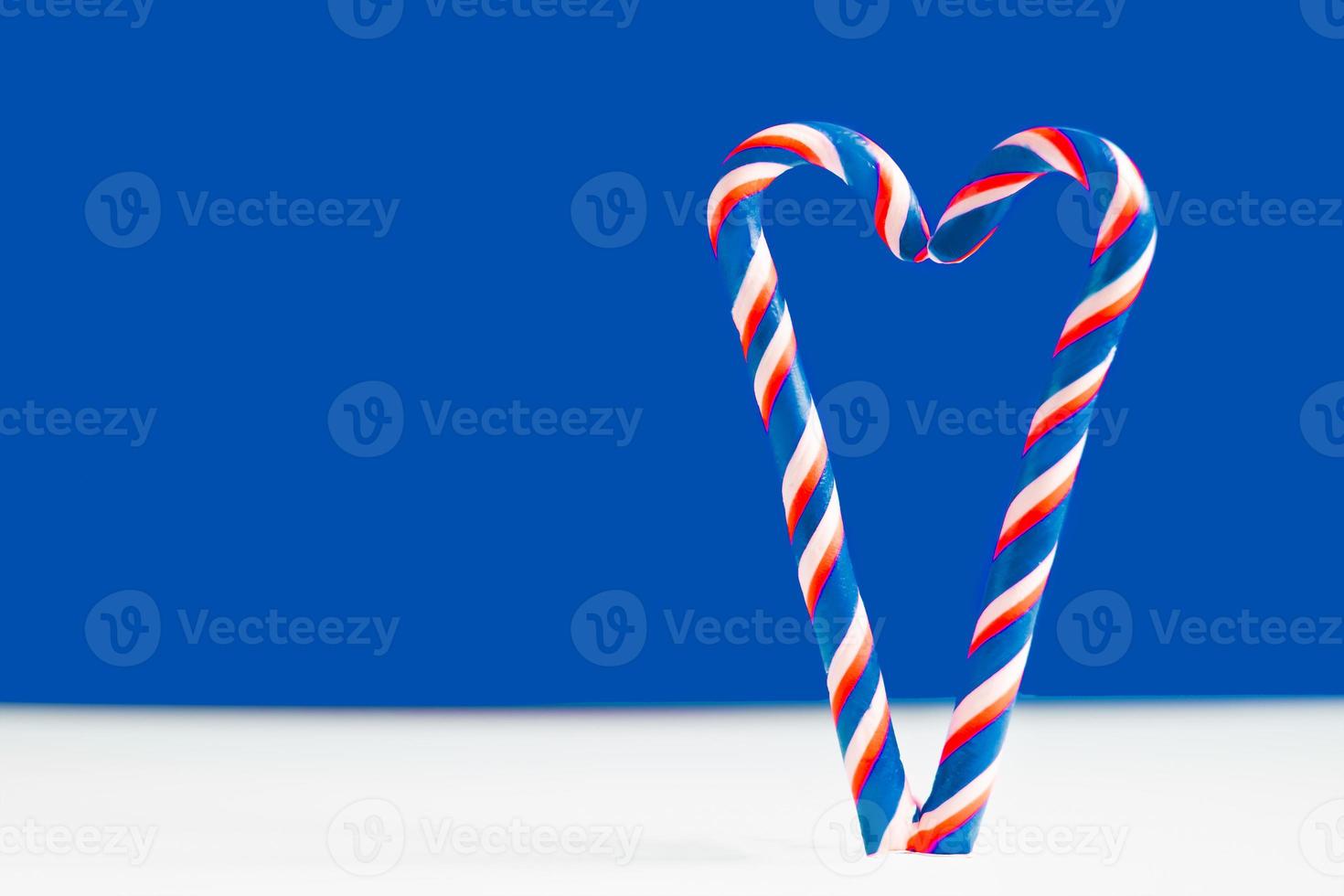 Christmas lollipops on a blue background. Heart on a blue background. Heart made of lollipops. Heart for valentine's day photo