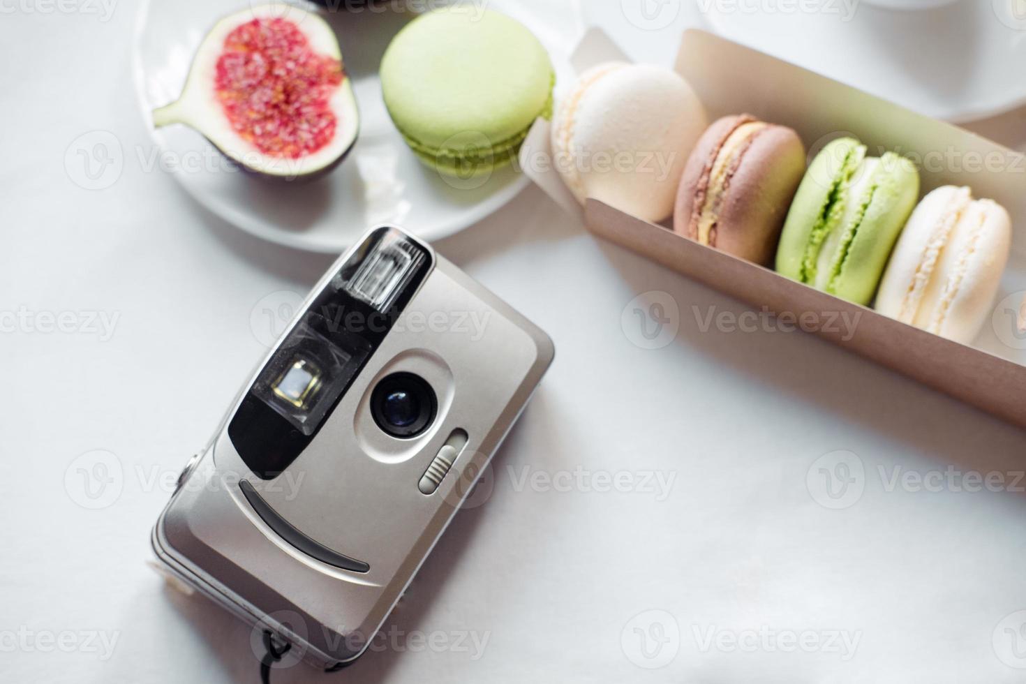 aesthetic film camera flatley, figs and macarons on white background, top view photo