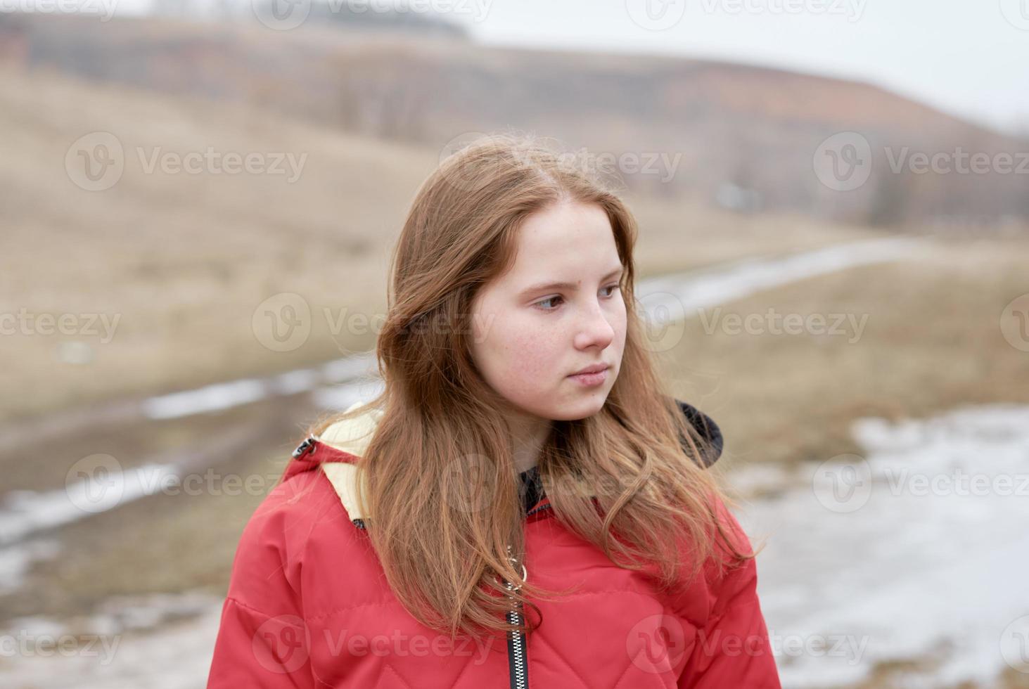 Cierra el retrato de una joven bonita con la cara pecosa en el campo de otoño. belleza, concepto de chica pelirroja foto