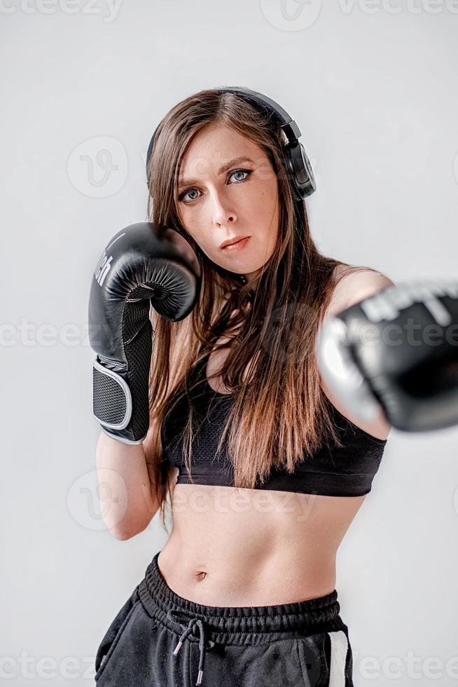 boxer girl. the girl strikes. shadow-boxing. boxing. women's boxing. girl with boxing gloves. crop top for sports. the girl's press. strong face photo