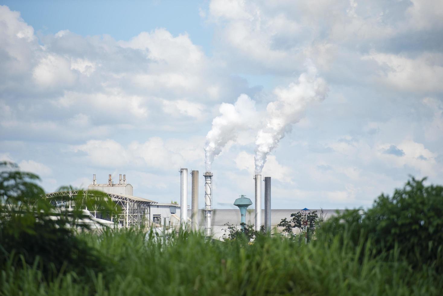 White smoke comes out from smokestacks or exhaust pipes in the factory chimneys emit water vapor which condenses into a whitish cloud before evaporating, Thick and heavy smoke coming out of a huge photo