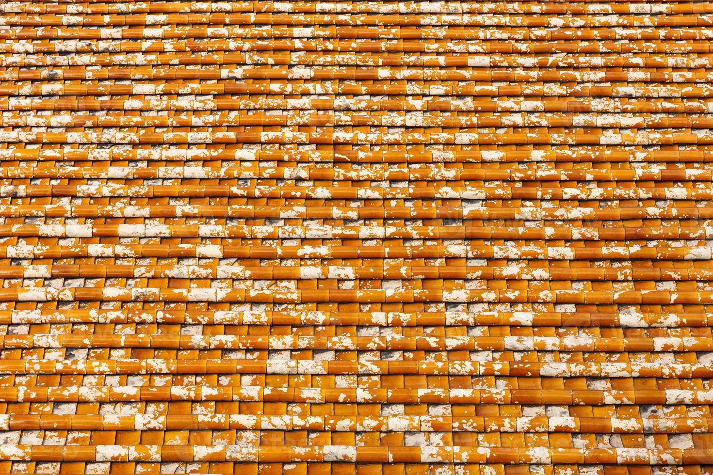 Tile roof texture, background of red tiles with white spots photo