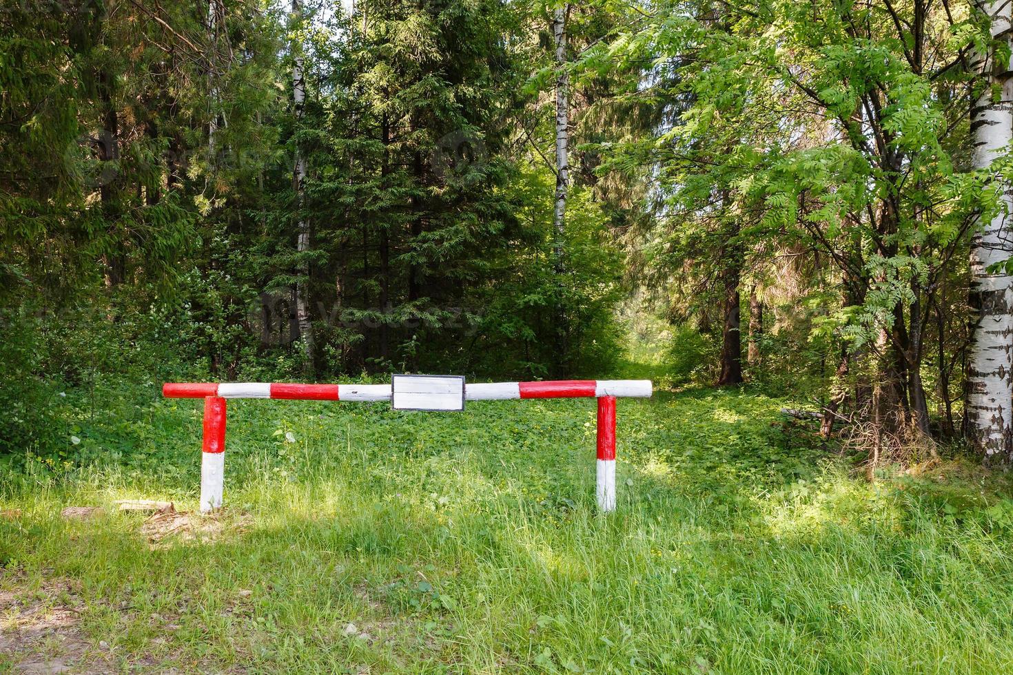 Red-white barrier in the forrest. photo