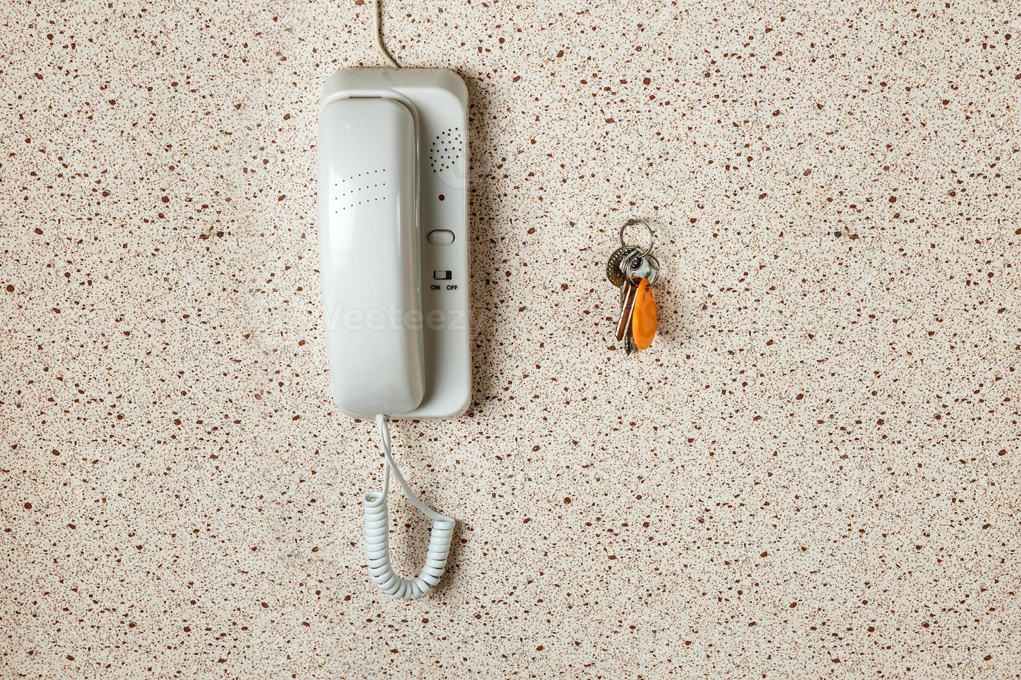 apartment keys and white intercom on the wall of the apartment. photo