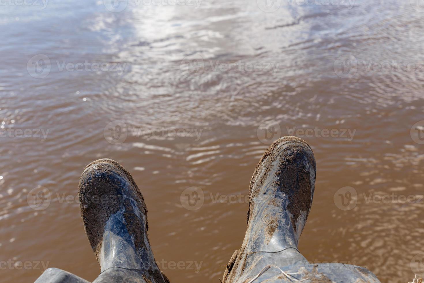 Feet of a traveler in black dirty boots photo