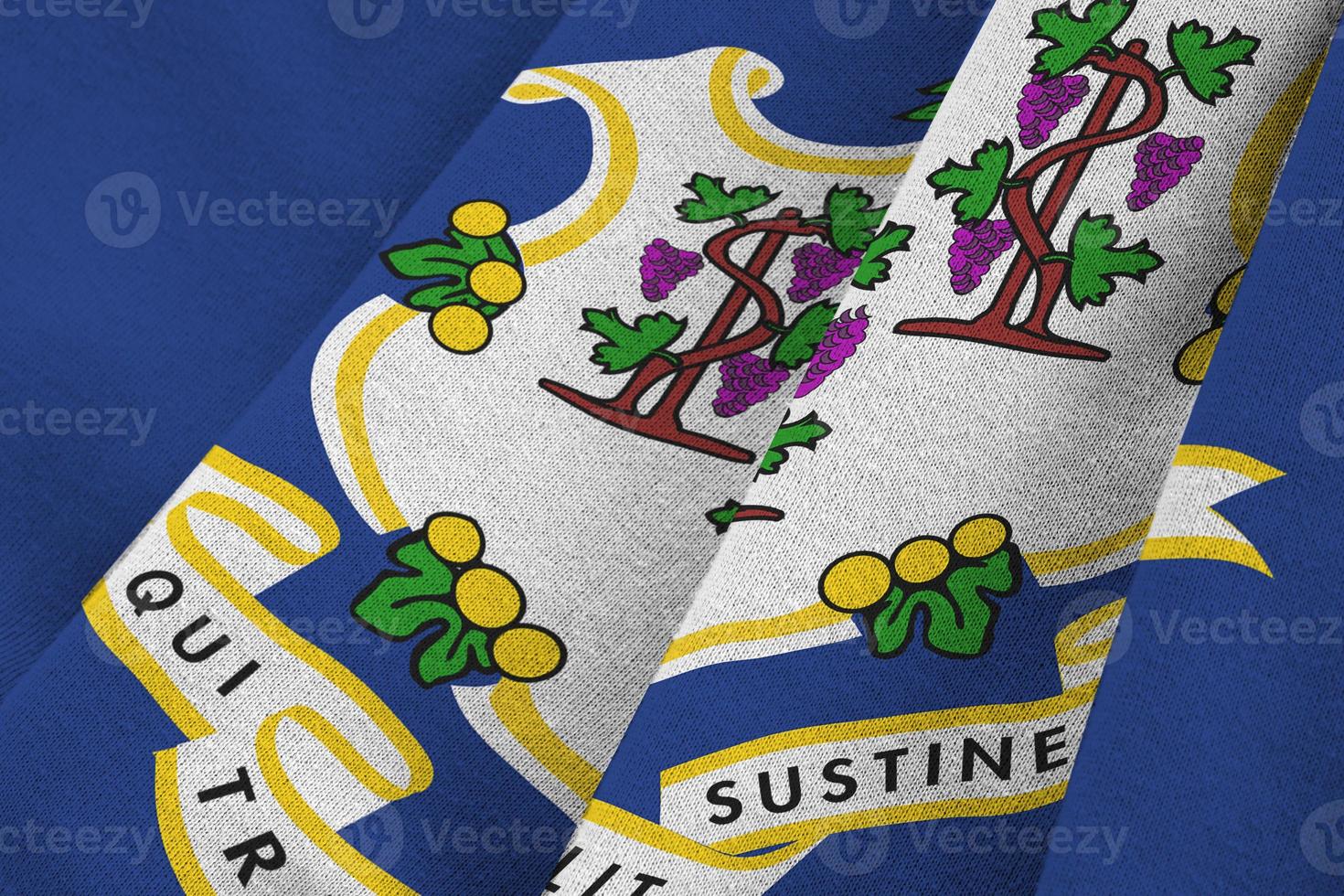 Connecticut US state flag with big folds waving close up under the studio light indoors. The official symbols and colors in banner photo