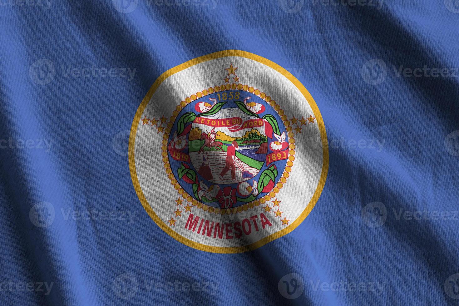 Minnesota US state flag with big folds waving close up under the studio light indoors. The official symbols and colors in banner photo
