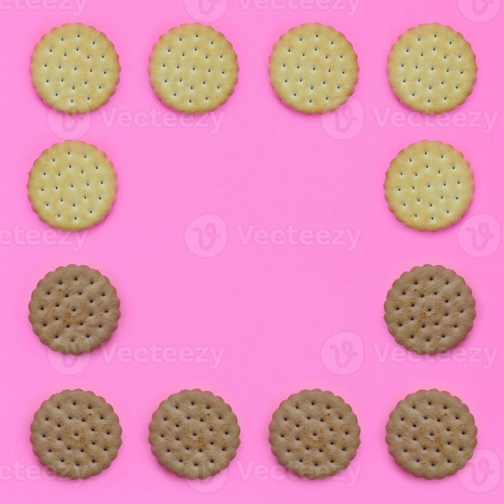 Pattern of a brown biscuits on a pink background. Trendy minimal concept of food and dessert. Abstract flat lay, top view photo