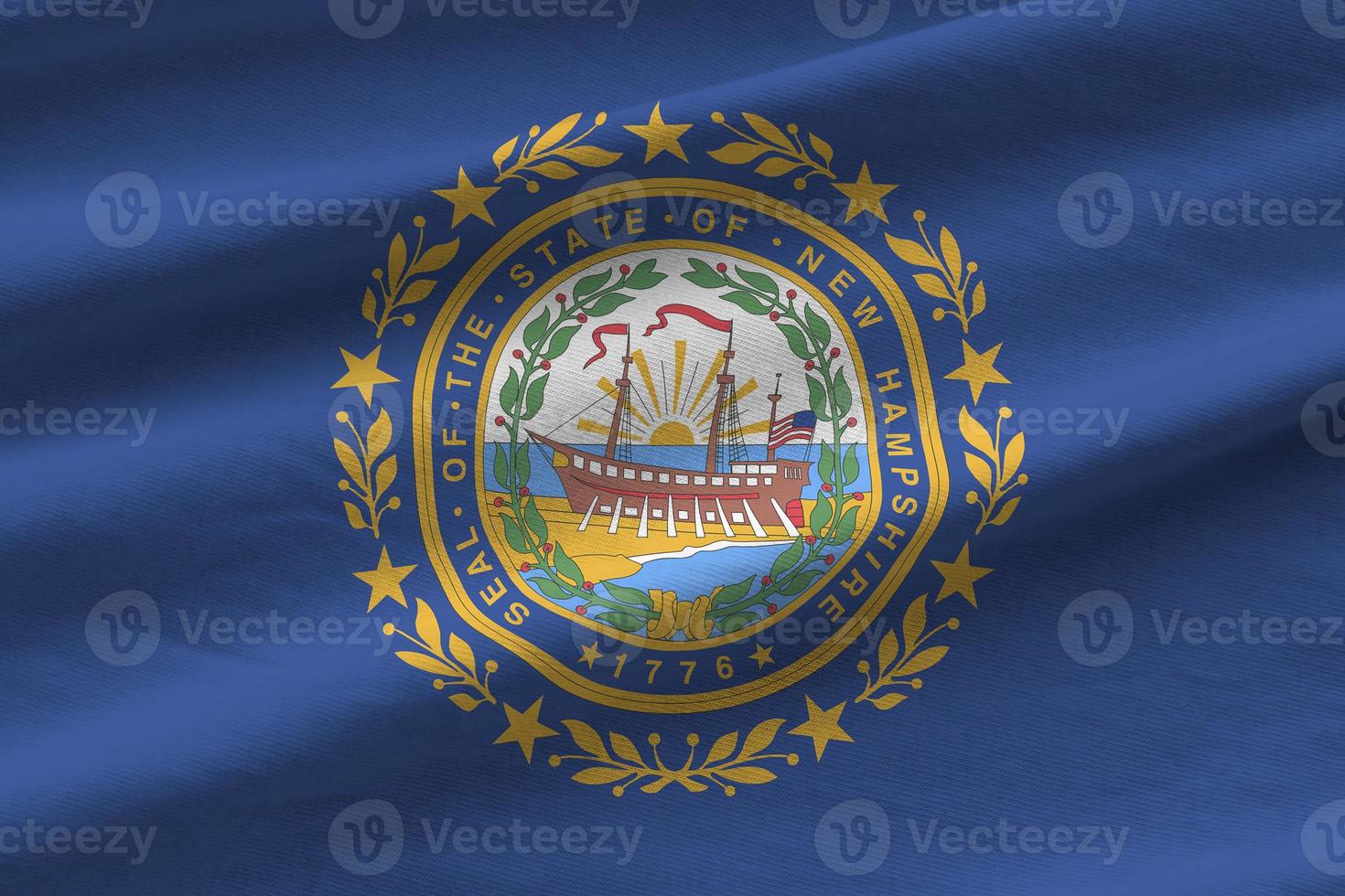 New Hampshire US state flag with big folds waving close up under the studio light indoors. The official symbols and colors in banner photo