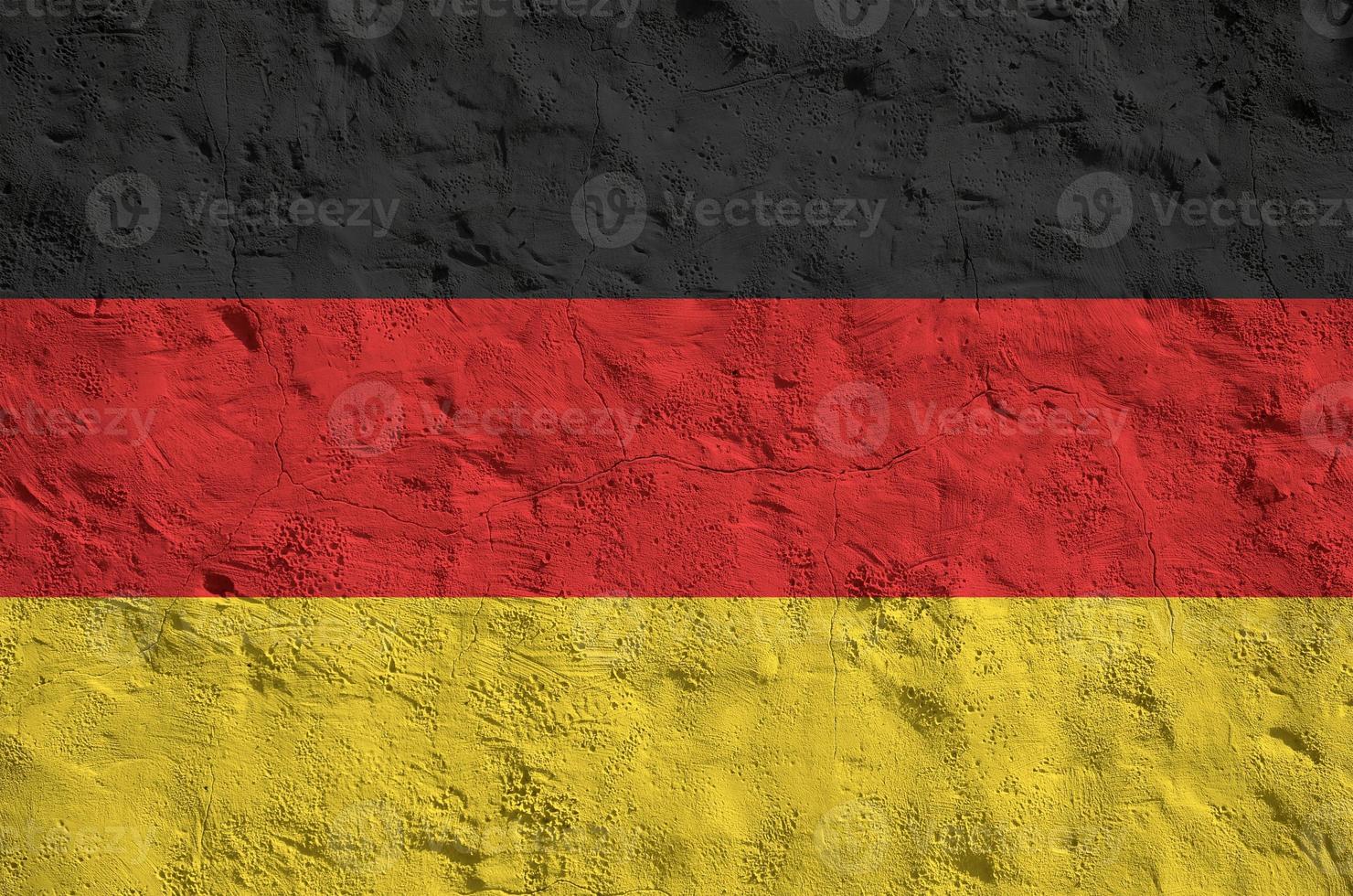 Germany flag depicted in bright paint colors on old relief plastering wall. Textured banner on rough background photo