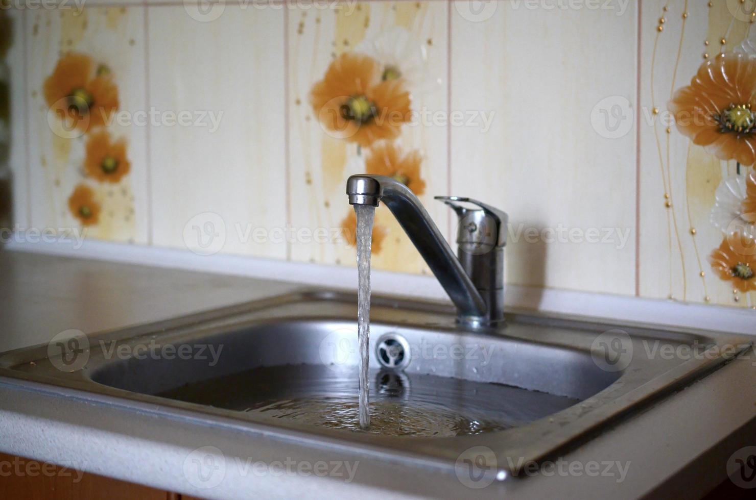 tapón del fregadero de acero inoxidable cerca del orificio lleno de agua y partículas de comida foto