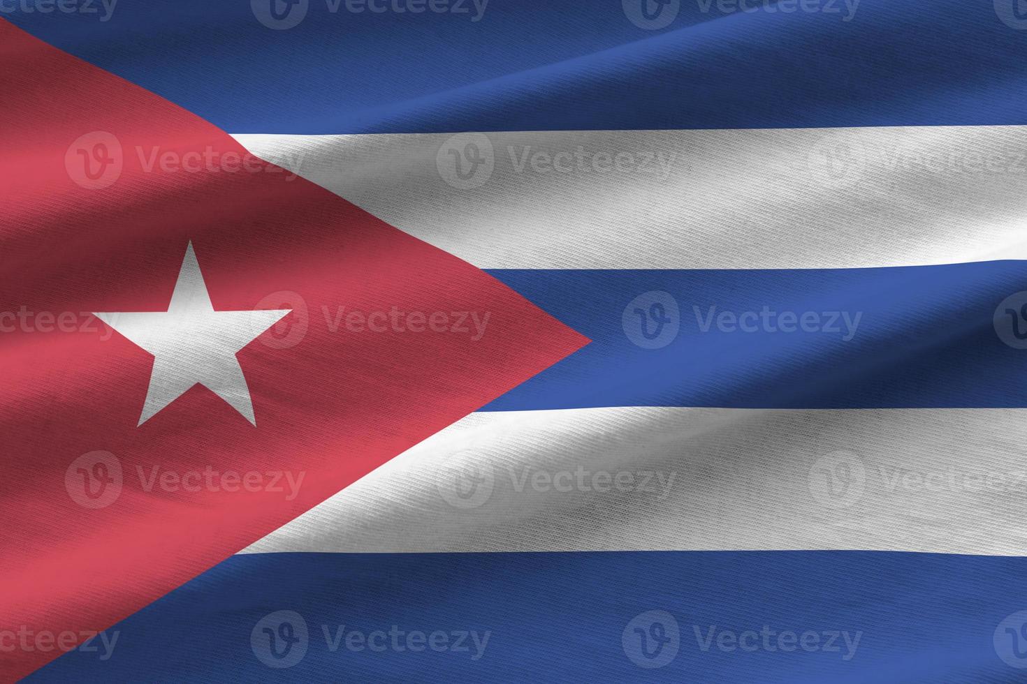 Cuba flag with big folds waving close up under the studio light indoors. The official symbols and colors in banner photo