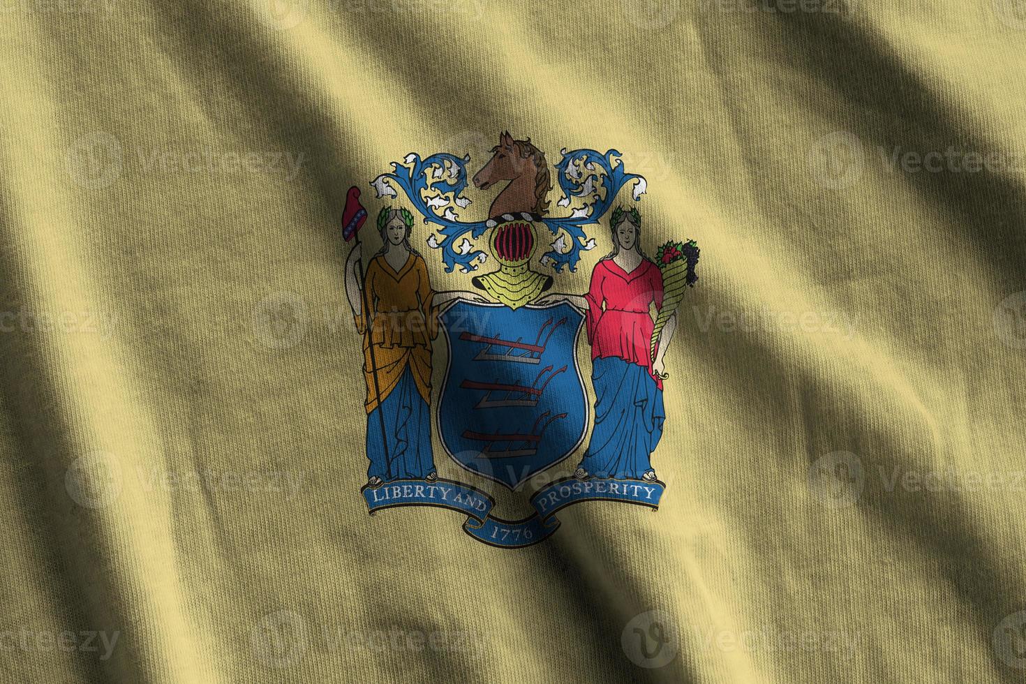 New Jersey US state flag with big folds waving close up under the studio light indoors. The official symbols and colors in banner photo