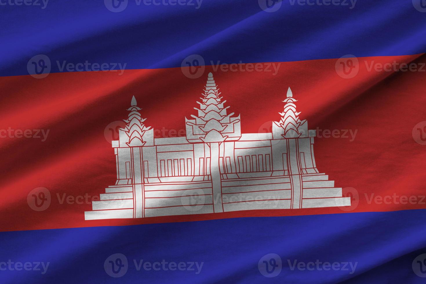 Cambodia flag with big folds waving close up under the studio light indoors. The official symbols and colors in banner photo