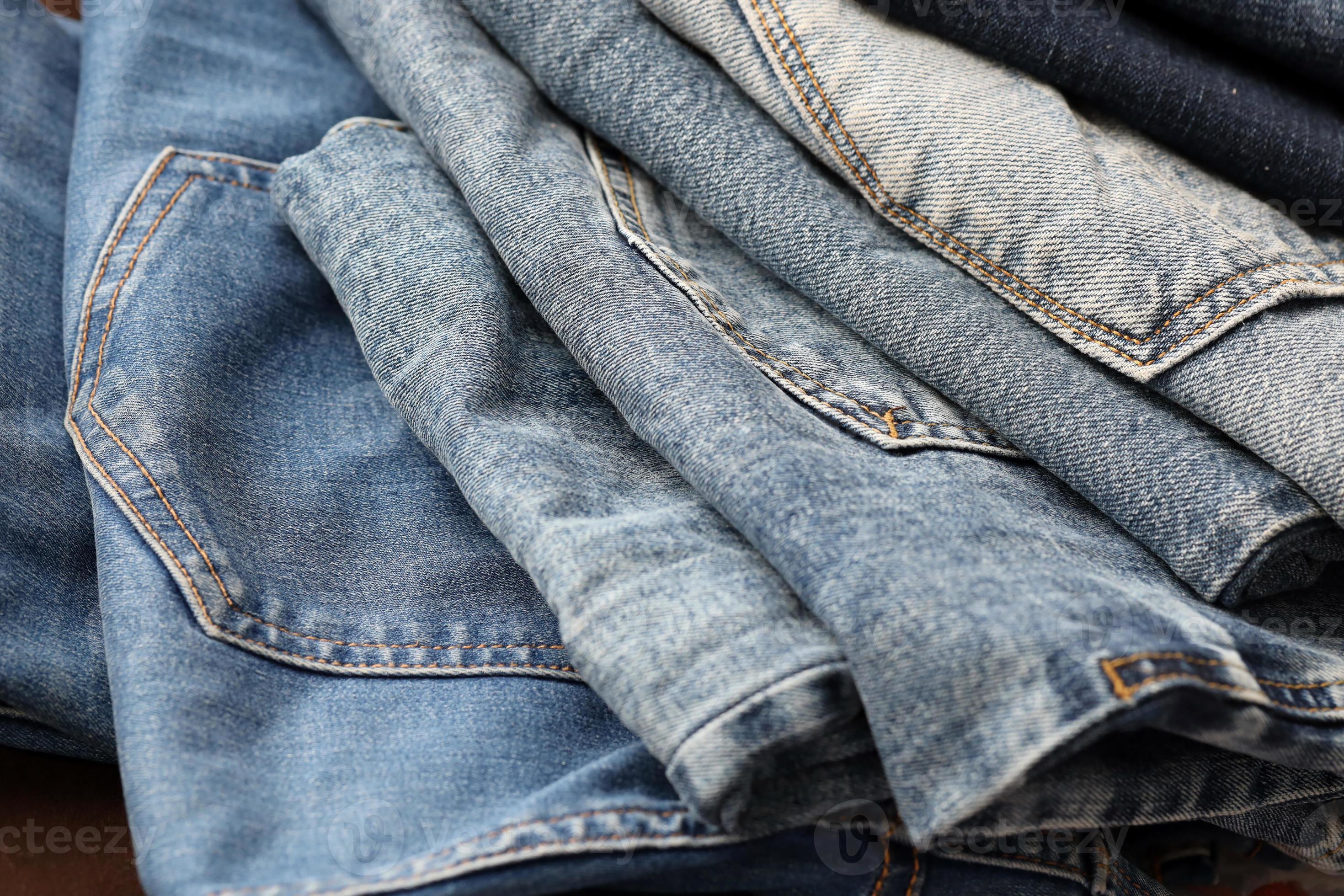 Many jeans in stack in wardrobe room. Row of pants denim jeans in closet.  Concept of buy, sell, shopping and fashionable clothes 14249418 Stock Photo  at Vecteezy
