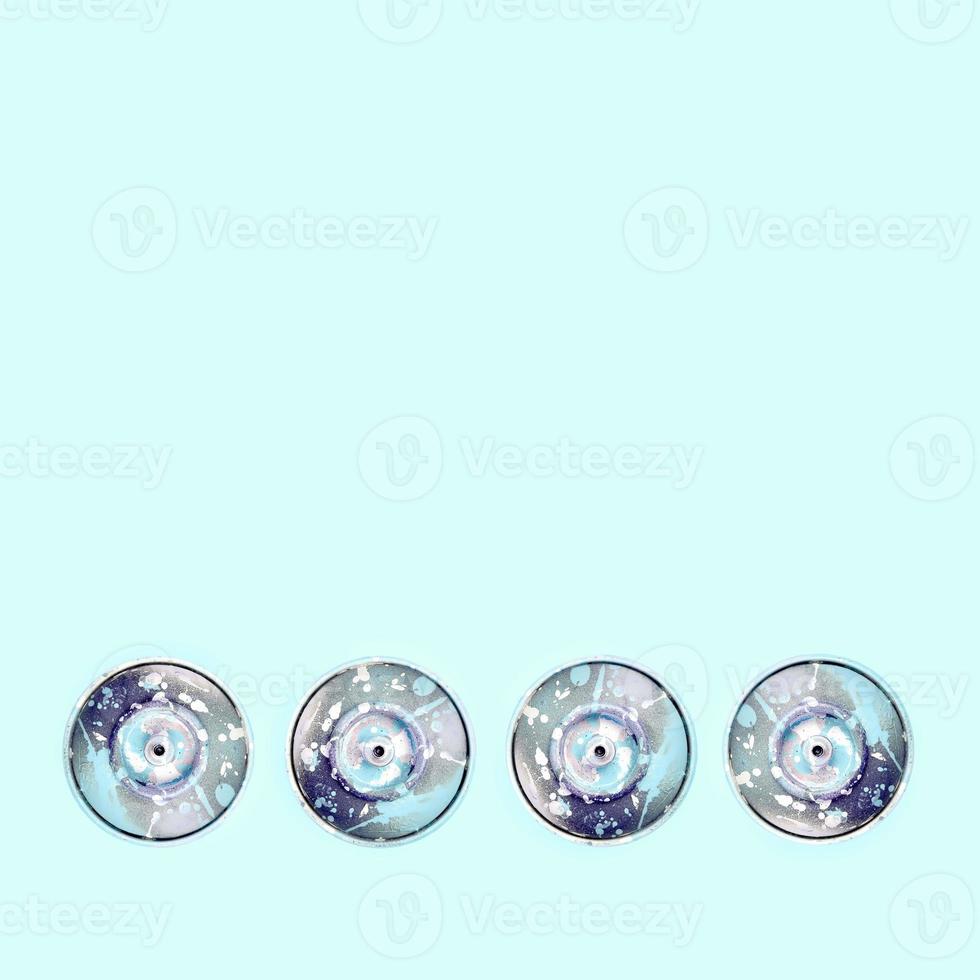 Many used spray cans for graffiti drawing lies on a pastel colored backgroung. Street art painting concept. Minimal flat lay pattern. Top view photo