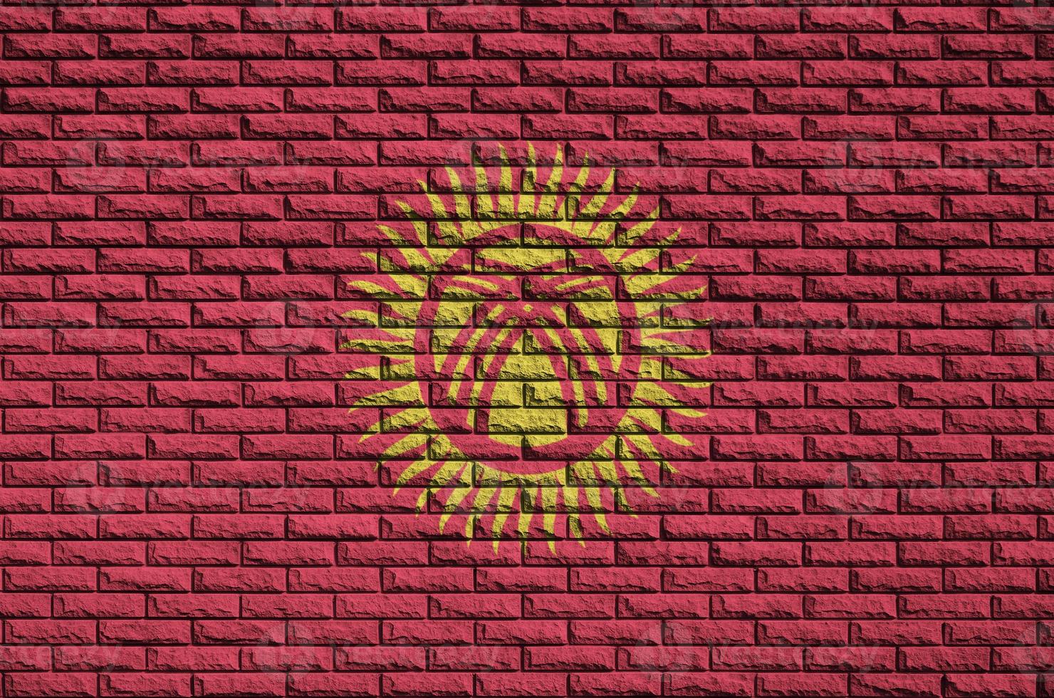 Kyrgyzstan flag is painted onto an old brick wall photo