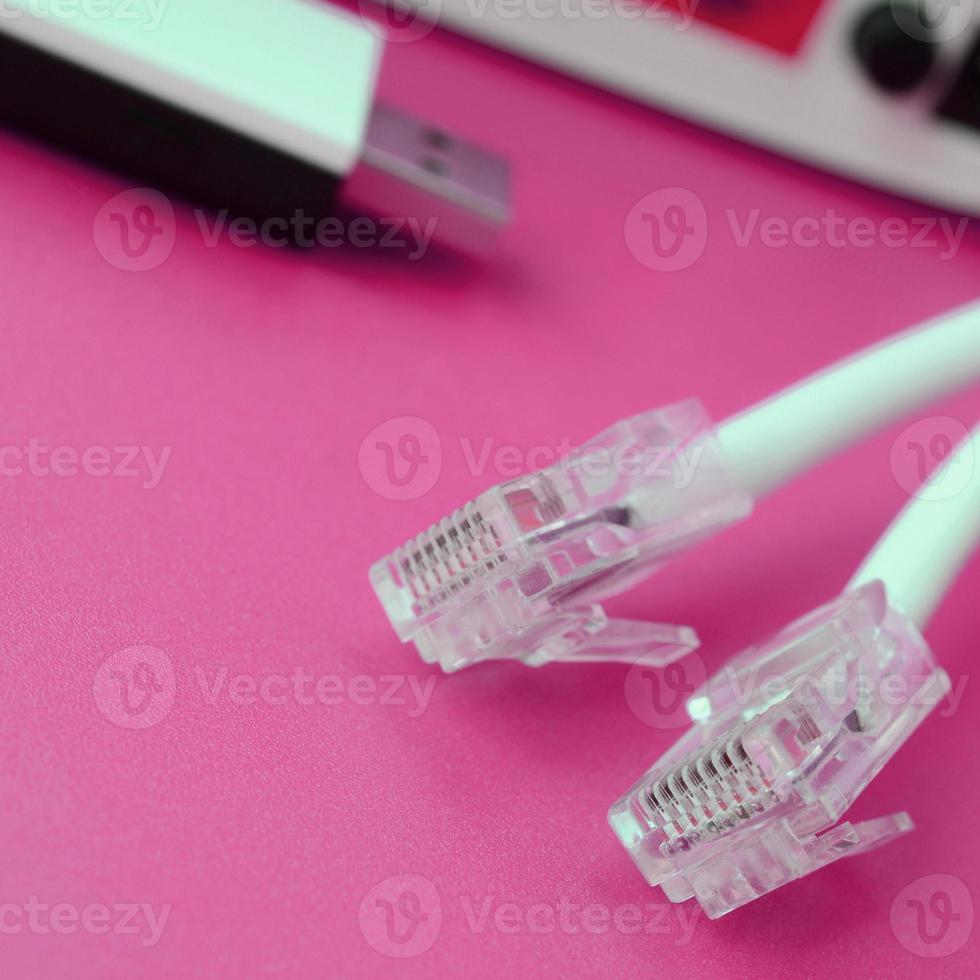Internet router, portable USB wi-fi adapter and internet cable plugs lie on a bright pink background. Items required for internet photo