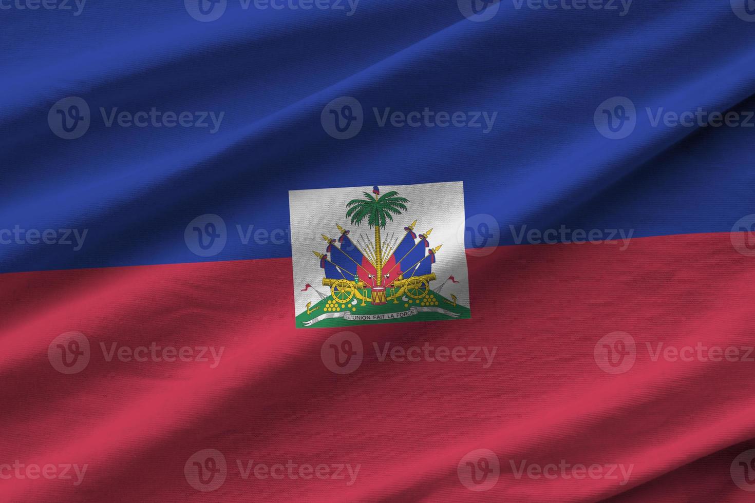 Haiti flag with big folds waving close up under the studio light indoors. The official symbols and colors in banner photo