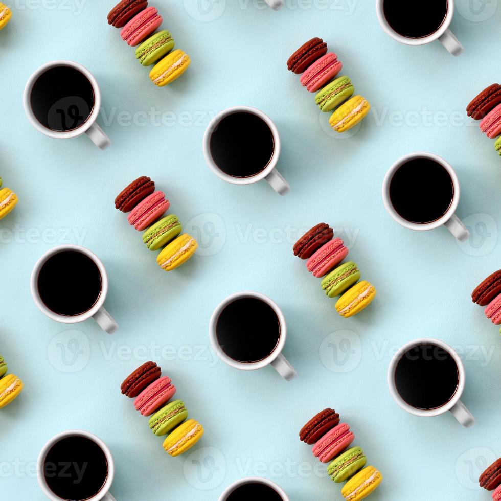 A pattern of many colorful dessert cake macaroon and coffee cups on trendy pastel blue background top view. Flat lay composition photo