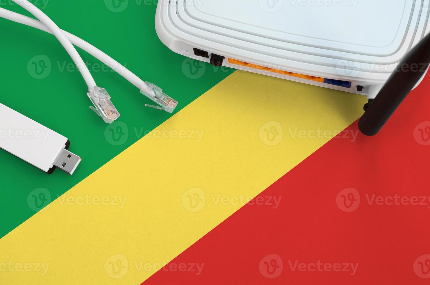 Congo flag depicted on table with internet rj45 cable, wireless usb wifi adapter and router. Internet connection concept photo