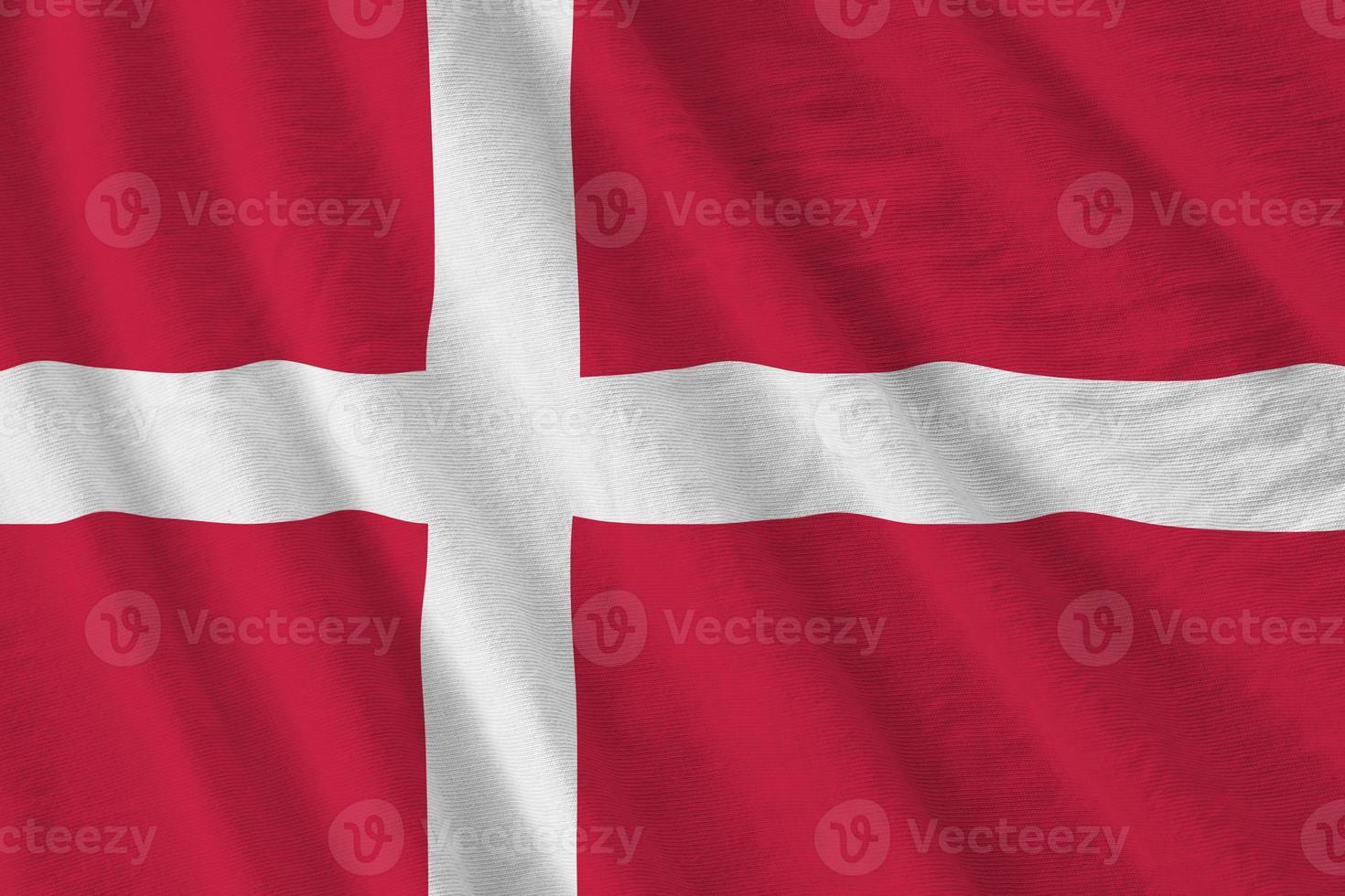 Denmark flag with big folds waving close up under the studio light indoors. The official symbols and colors in banner photo