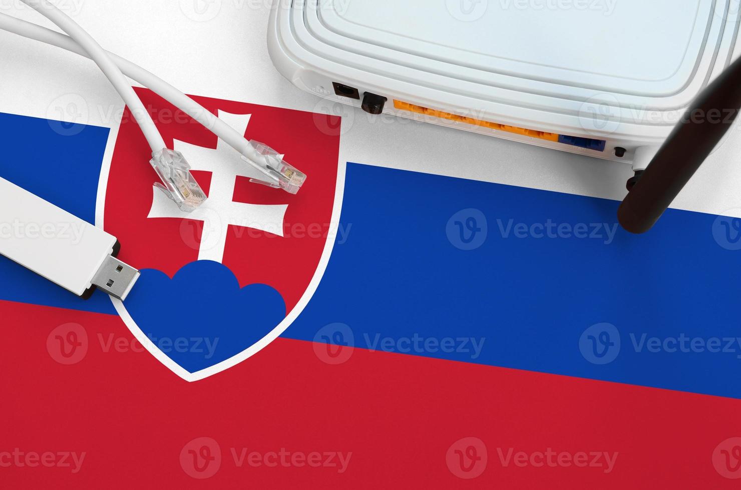 Slovakia flag depicted on table with internet rj45 cable, wireless usb wifi adapter and router. Internet connection concept photo