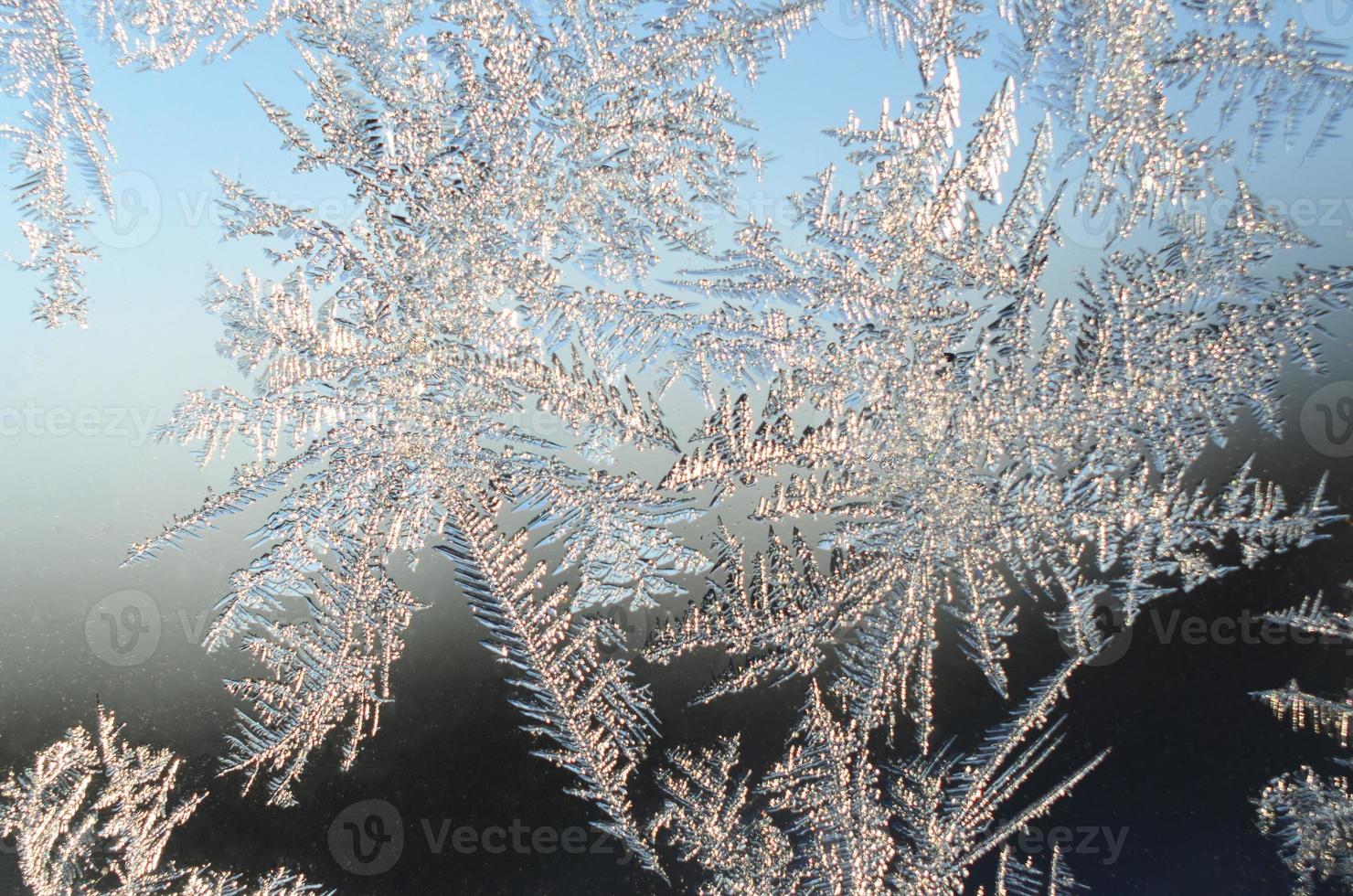 Snowflakes frost rime macro on window glass pane photo