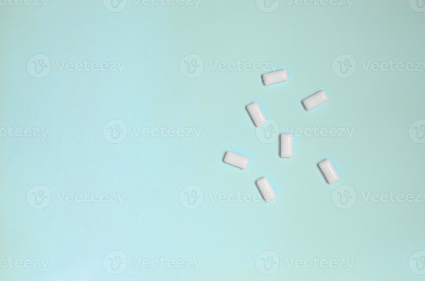 A few chewing gums lie on texture background of fashion pastel blue color paper in minimal concept photo