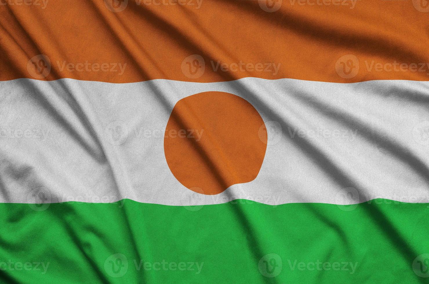 Niger flag  is depicted on a sports cloth fabric with many folds. Sport team banner photo