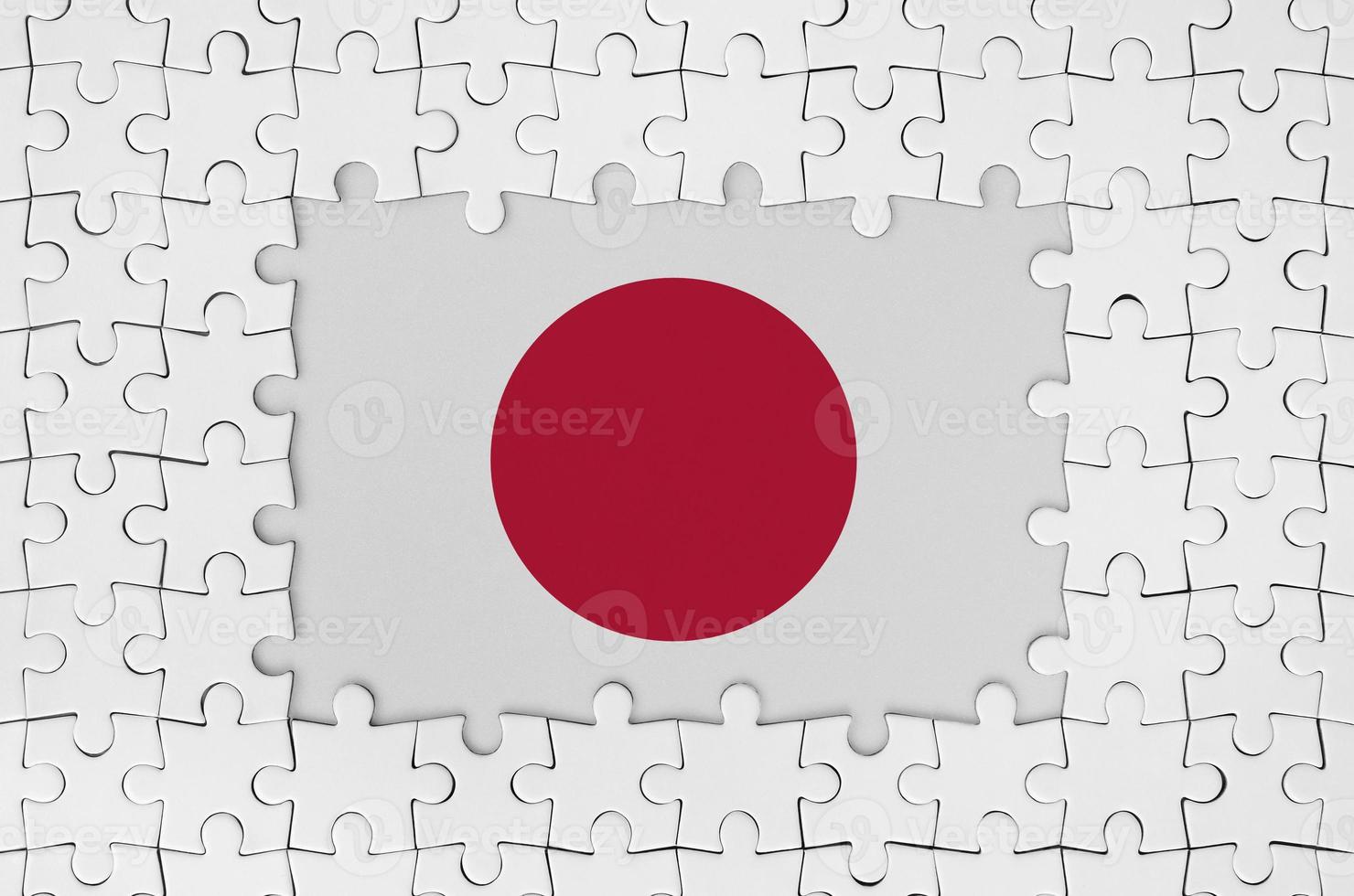 Japan flag in frame of white puzzle pieces with missing central part photo