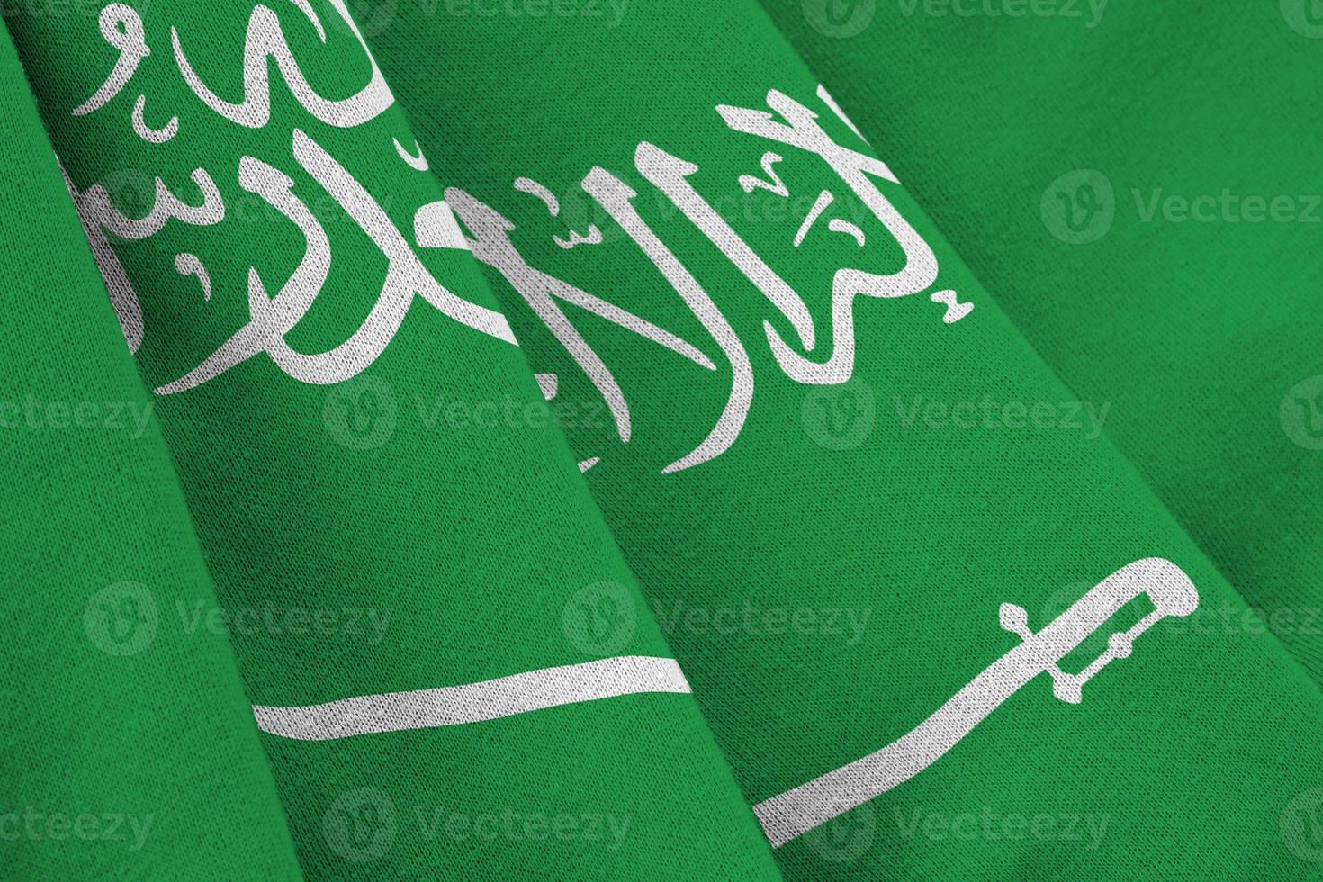 Saudi Arabia flag with big folds waving close up under the studio light indoors. The official symbols and colors in banner photo