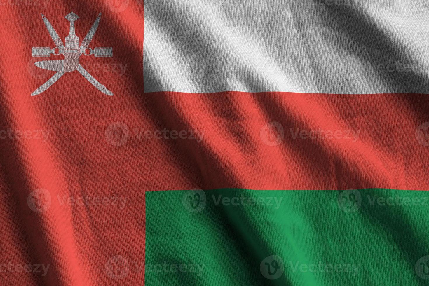 Oman flag with big folds waving close up under the studio light indoors. The official symbols and colors in banner photo