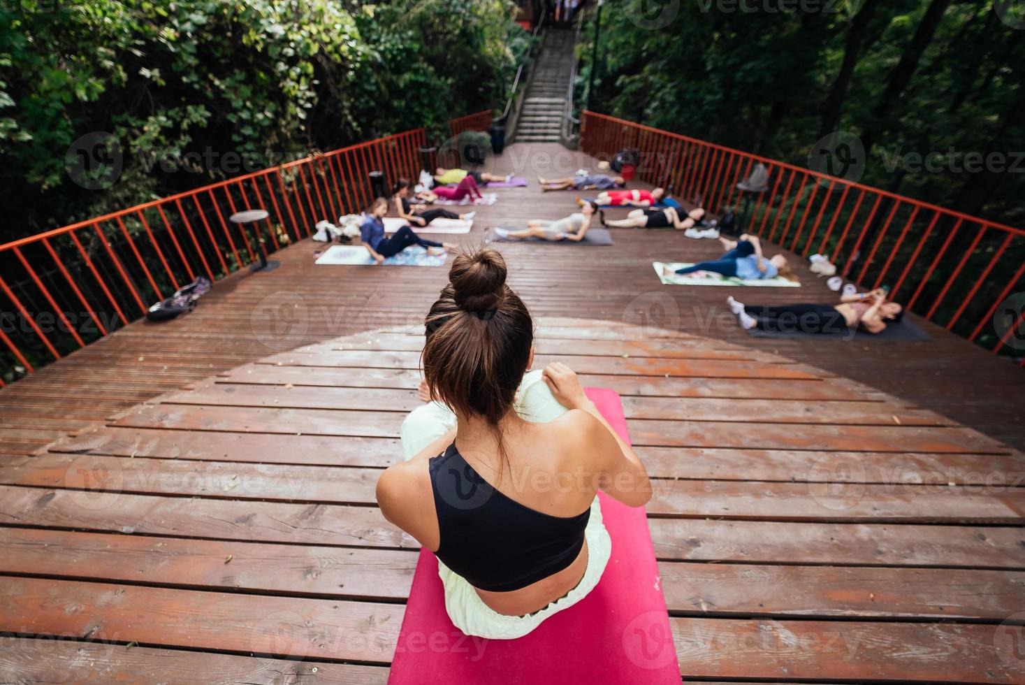 grupo de jóvenes deportistas practicando clases de yoga con instructor, foto