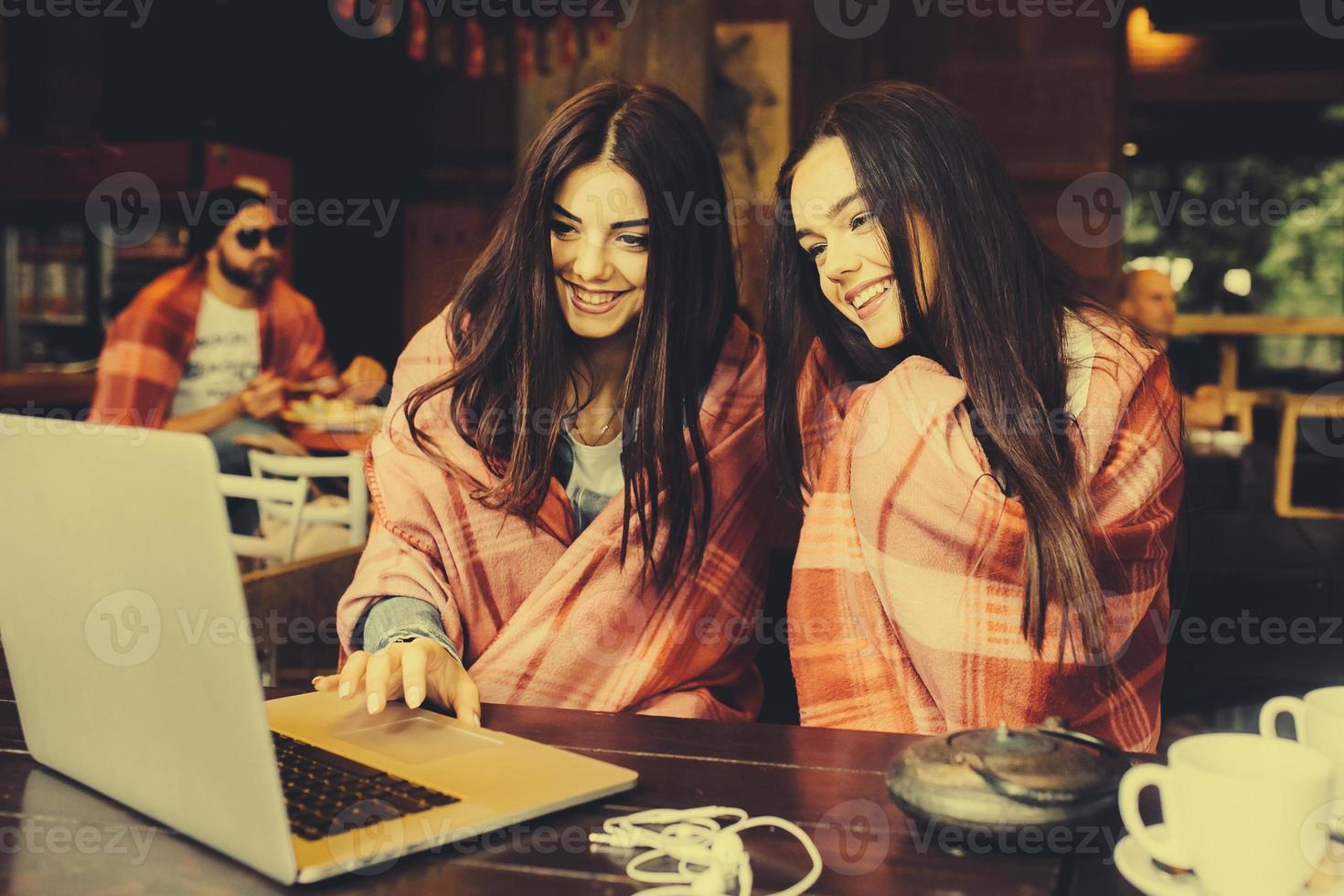 dos chicas viendo algo en la computadora portátil foto