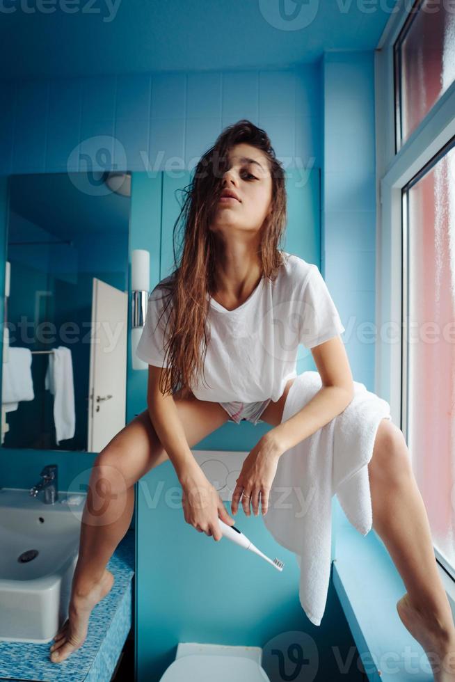 Beautiful, young woman in the bathroom is having fun photo