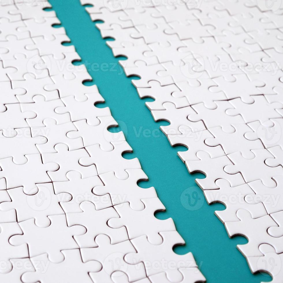 The blue path is laid on the platform of a white folded jigsaw puzzle. Texture image with copy space for text photo