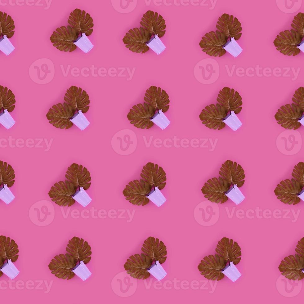 Tropical palm monstera leaves lies in a pastel pails on a colored background. Flat lay trendy minimal pattern. Top view photo