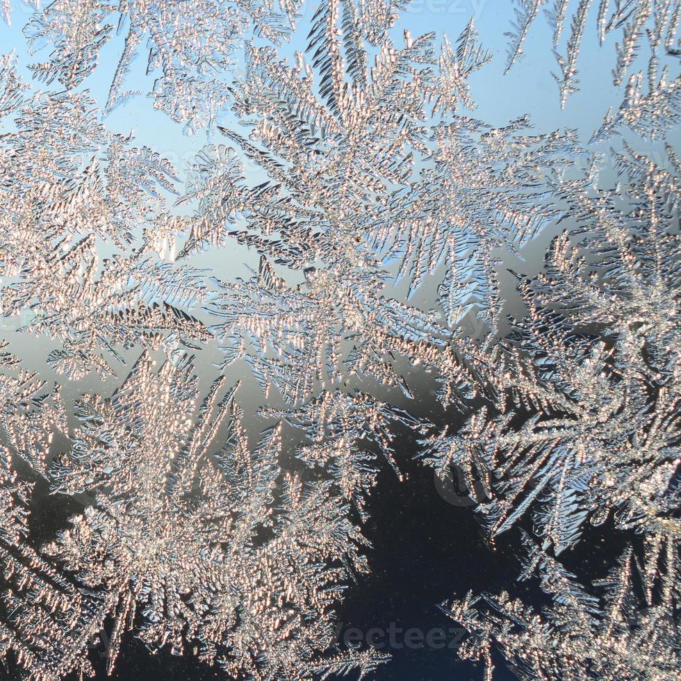 Snowflakes frost rime macro on window glass pane photo