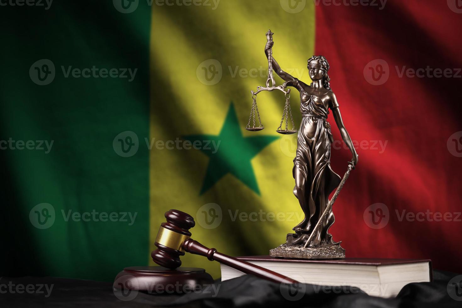 Senegal flag with statue of lady justice, constitution and judge hammer on black drapery. Concept of judgement and guilt photo