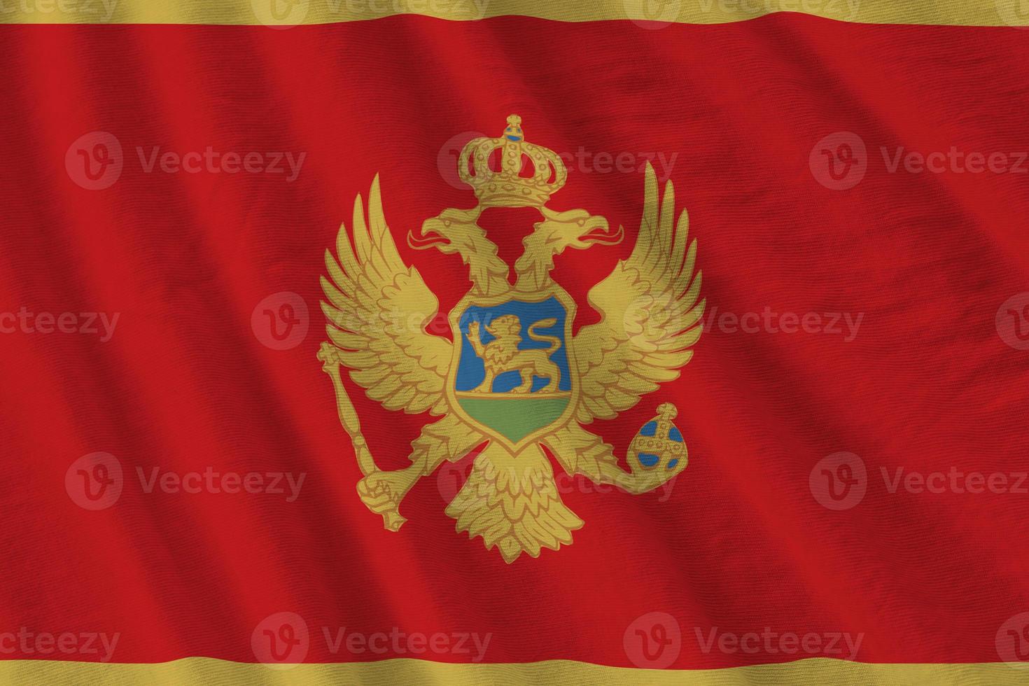 Montenegro flag with big folds waving close up under the studio light indoors. The official symbols and colors in banner photo