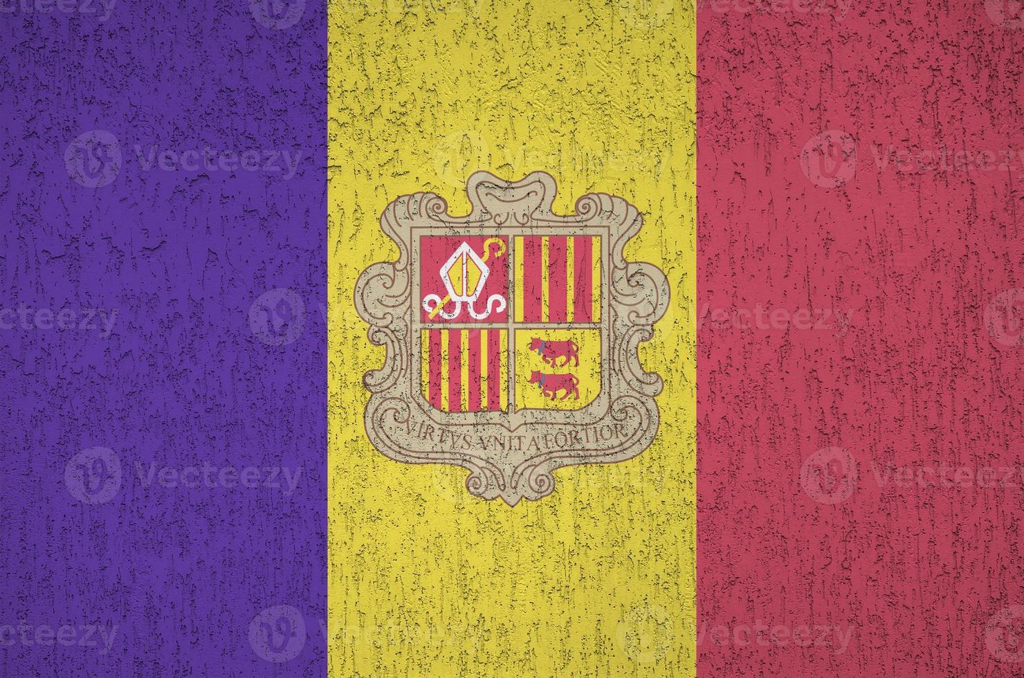 Andorra flag depicted in bright paint colors on old relief plastering wall. Textured banner on rough background photo