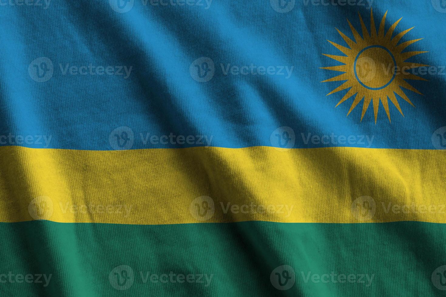 Rwanda flag with big folds waving close up under the studio light indoors. The official symbols and colors in banner photo