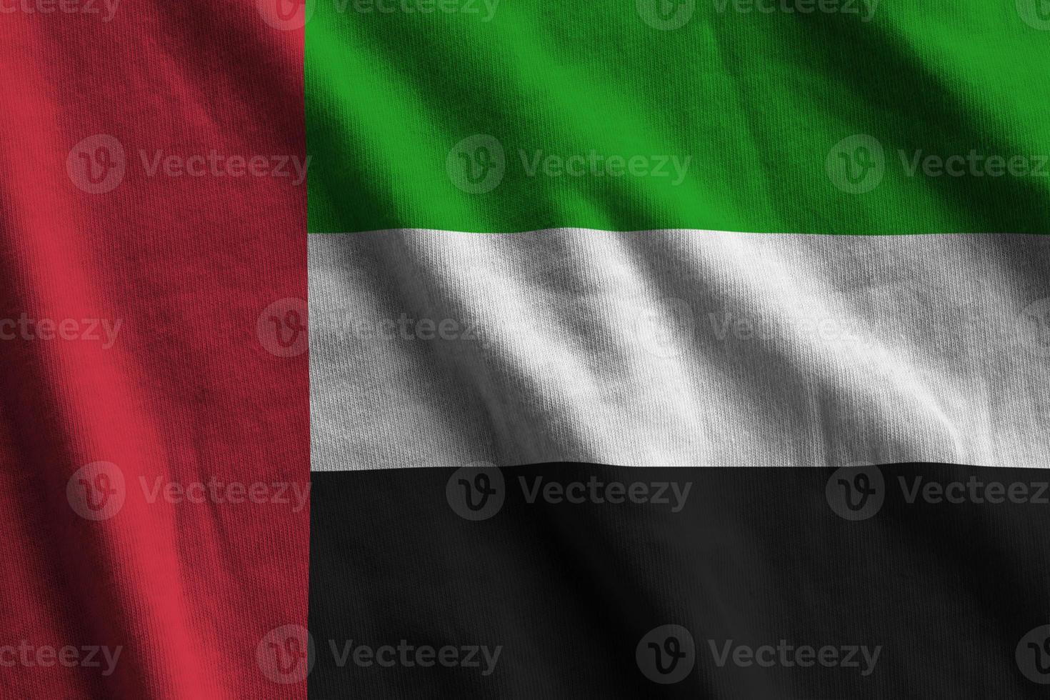 United Arab Emirates flag with big folds waving close up under the studio light indoors. The official symbols and colors in banner photo