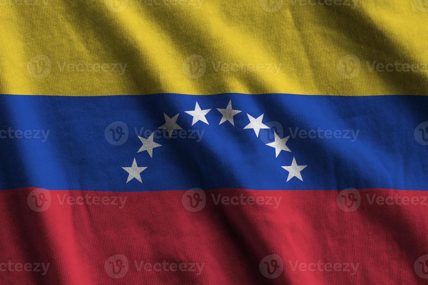 bandera de venezuela con grandes pliegues ondeando de cerca bajo la luz del estudio en el interior. los símbolos y colores oficiales en banner foto