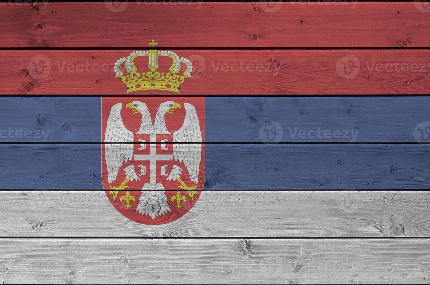 Serbia flag depicted in bright paint colors on old wooden wall. Textured banner on rough background photo
